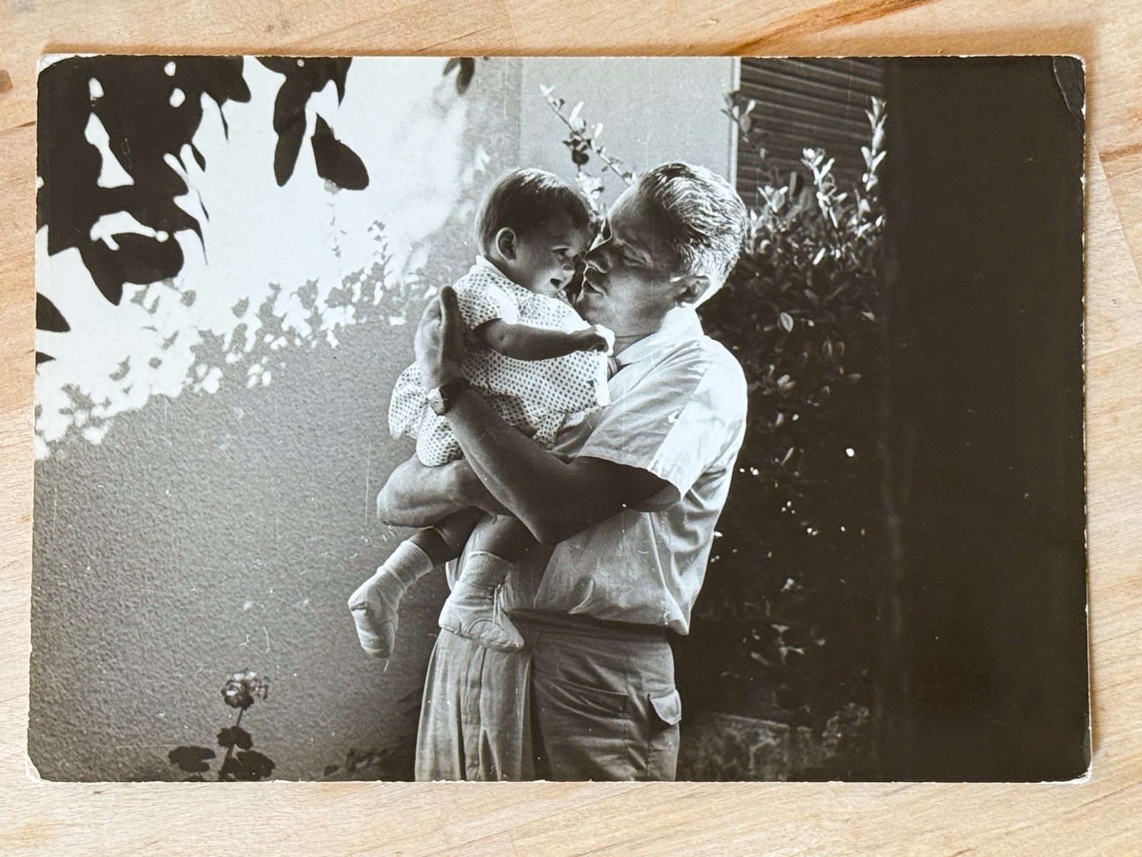 An old printed family photograph of a father holding his child